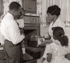 Family looking at oven-and roast turkey 1960s