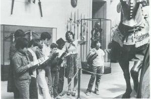 Barbara Pollard and a group of children in the Arts & Armor Gallery. junior museum