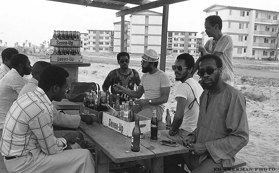 Festac '77 Village Lagos, Federal Republic of Nigeria -West Africa - 2nd World Festival of Art & Culture, Lagos, Nigeria (January, 1977), Photo by Edward Sherman l to r..artists /Reggie Jackson...Nelson Stevens...Napoleon Jones Henderson Ademola Olugebefola...standing is musician Nadi Quamar, seated opposite us are unidentified Nigerians.